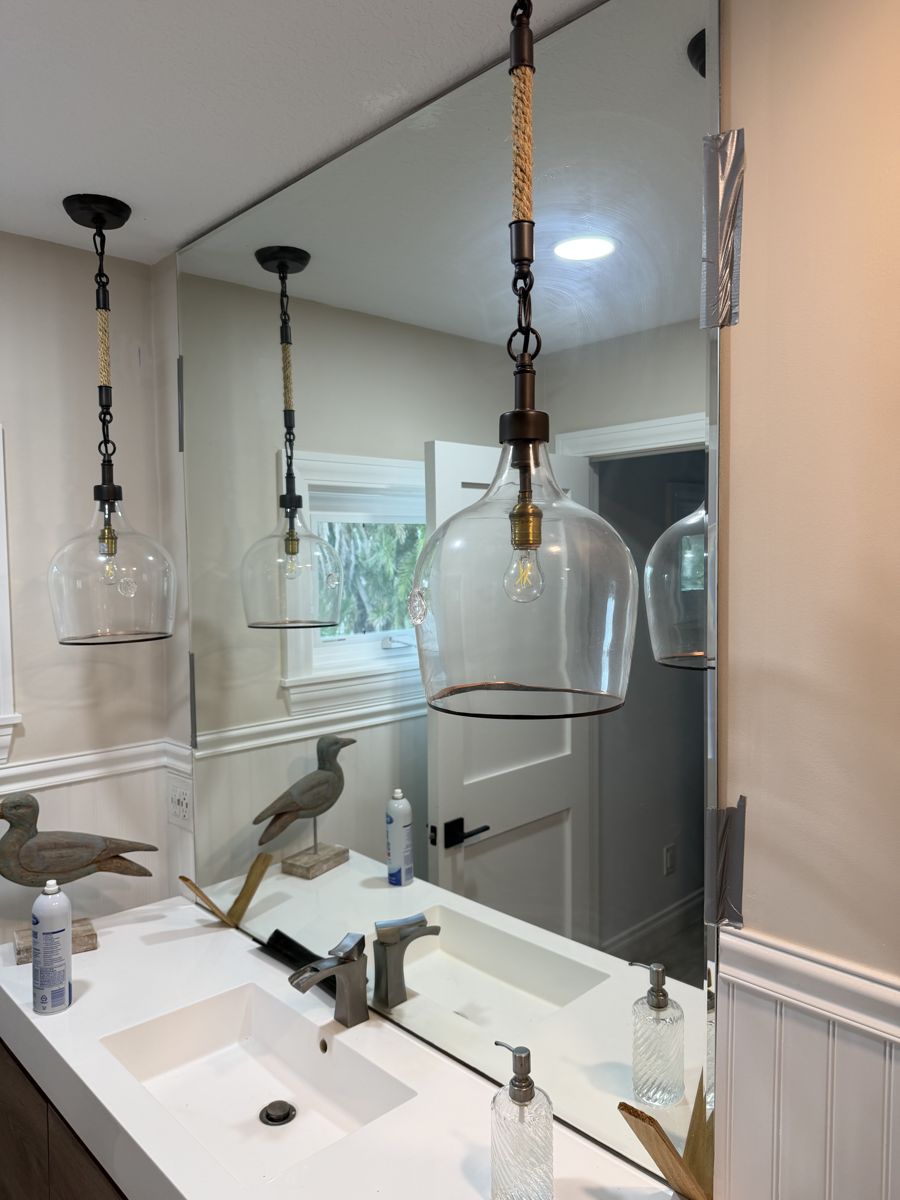 Glass pendant lights hung over a double bathroom vanity in Madeira Beach, FL